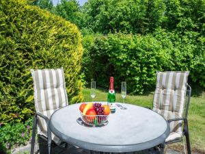 ein Tisch mit einer Schale Obst und einer Flasche Wein in der Unterkunft Feriendorf Rugana - Budget 1-Raum Appartement mit Terrasse A10 in Dranske