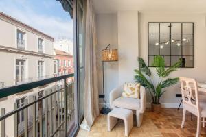 Camera dotata di balcone con sedia e finestra. di Cervantes Luxury Apartment a Málaga