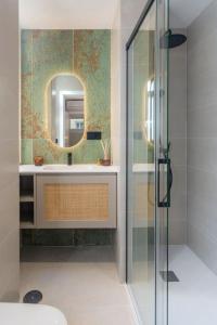 un bagno con doccia, lavandino e specchio di Cervantes Luxury Apartment a Málaga Altre 13 foto