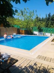 a swimming pool with two people in the water at Gardan Bungalov in Çatalca
