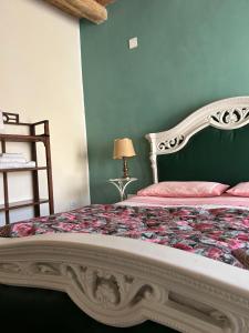 a bedroom with a bed with a floral bedspread at B&B Casa CamiLory in San Lucido