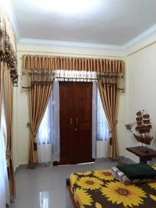 een slaapkamer met een bed en een deur met gordijnen bij Bukit Lawang in Bukit Lawang