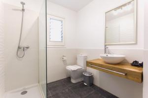 a bathroom with a sink and a toilet and a shower at Apartamentos Gama in Cala Galdana