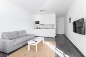 a living room with a couch and a table at Apartamentos Gama in Cala Galdana