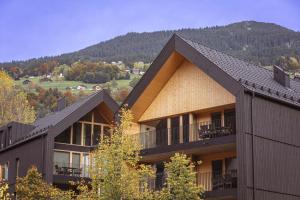 a large building with a mountain in the background at Montafon Suites Schruns by ALPS RESORTS in Schruns