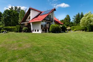 a house with a red roof with a large yard at Domek letniskowy Patricia in Sulęczyno