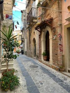 an alley with a palm tree in an old building at B&B Casa CamiLory in San Lucido