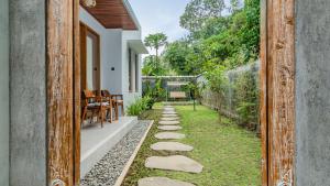 a backyard with a stone walkway next to a house at Suweca House in Ubud