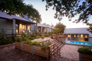 a home with a swimming pool and a house at Mont Angelis in Stellenbosch