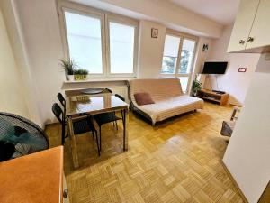 salon z kanapą i stołem w obiekcie Green Kabaty Apartment 1 w Warszawie