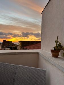 a sunset from a balcony with a plant on the ledge at B&B Casa CamiLory in San Lucido