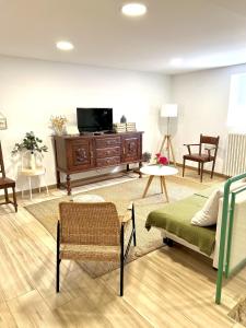 a living room with a tv and a couch and chairs at Fantástica Casa Rural en Castrillo Mota de Judíos in Burgos