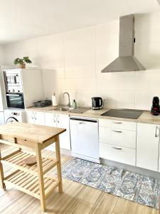 a kitchen with white cabinets and a wooden table at Fantástica Casa Rural en Castrillo Mota de Judíos in Burgos +7 photos