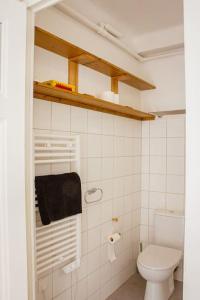 a white bathroom with a toilet and a towel at Le montagnard - Nature, parking in Albertville