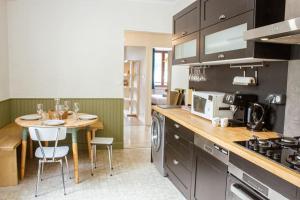 a kitchen with a table with chairs and a dining room at Le montagnard - Nature, parking in Albertville +16 photos