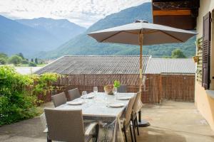 a table with an umbrella on a patio at Le montagnard - Nature, parking in Albertville