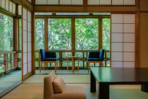 a screened in porch with two chairs and a table at Tsukihitei in Nara