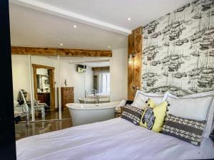 1 dormitorio con cama, bañera y lavamanos en Con-Mar, en Shaldon