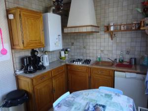 a small kitchen with wooden cabinets and a sink at Maison avec jardin à Vierzon in Vierzon