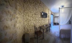 a living room with a table and a wall at A cantunera o castieddu in Naro