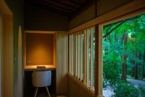 a room with a desk and a window with a chair at Tsukihitei in Nara