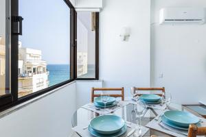 een eetkamer met een tafel en uitzicht op de oceaan bij Vieira Casino in Armação de Pêra
