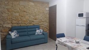 a living room with a blue couch and a table at A cantunera o castieddu in Naro