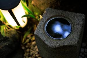 a stone bird house with a blue reflection in it at Tsukihitei in Nara