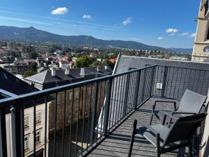 a chair on a balcony with a view of a city at Hotel Praha Liberec in Liberec