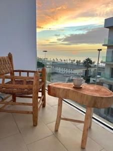 einen Tisch und einen Stuhl auf einem Balkon mit Aussicht in der Unterkunft N9 Appartement pied sur mer, La Corniche Rabat in Rabat
