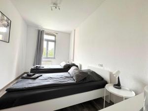 two beds in a small room with a window at Fully equipped Apartment with Balcony in Zwickau