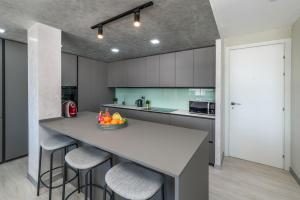 eine Küche mit einer großen Insel mit Barhockern in der Unterkunft Brand New Luxury 3BR with Private Hammam in Chalong 