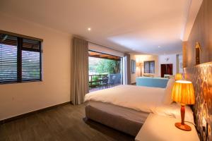 a bedroom with a bed and a large window at Mont Angelis in Stellenbosch +175 photos