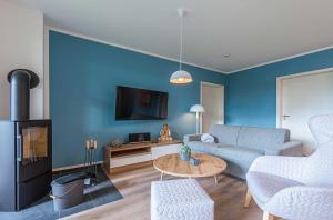 a living room with a couch and a table at Yoga-Oase am Krakower See - Erdgeschoss mit Terrasse, Kamin & Sauna in Krakow am See