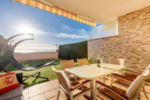 a patio with a table and chairs and a playground at Residencial Playa de La Arena in Puerto de Santiago