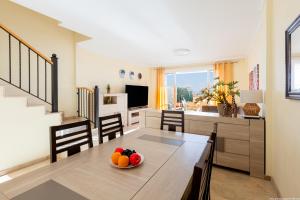 a dining room with a table with a bowl of fruit on it at Residencial Playa de La Arena in Puerto de Santiago