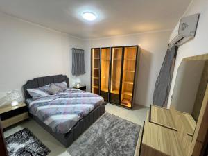 a bedroom with a bed and a dresser at Pyramid Heights Apartments in Cairo +39 photos