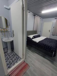 a small bedroom with a bed and a sink at SKY Homestay in Kota Bharu