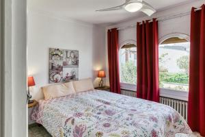 a bedroom with a bed and two windows with red curtains at Art- Apartamentos Revilla Tacke G in Empuriabrava +25 photos