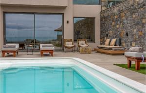 a swimming pool in front of a house with a patio at Beautiful Home In Heraklio Crete in Lygaria