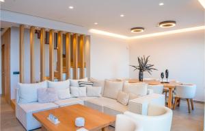 a living room with a white couch and a table at Beautiful Home In Heraklio Crete in Lygaria