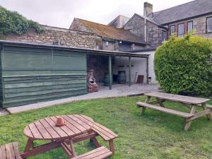two picnic tables in the grass next to a garage at St aubyn arms Hotel in Praze an Beeble