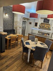 a dining room with tables and chairs and a kitchen at St aubyn arms in Pool