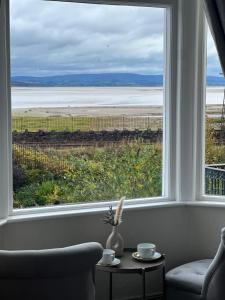 a room with a window with a view of the ocean at The Commodore Inn in Grange Over Sands