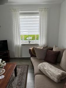 a living room with a couch and a table and a window at Ferienwohnung Sylt in Meinerzhagen