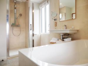 a white bathroom with a shower and a sink at Logis Hôtel de Carantec in Carantec