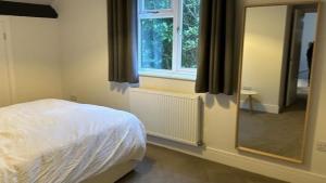 En eller flere senge i et værelse på Charming Two Bedroom Cottage Hedsor