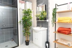 a bathroom with a shower and a sink and plants at Kalima - proche de CDG et du Parc Asterix in Dammartin-en-Goële