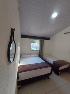 a small room with two beds and a mirror at Quarto em Guarapari 5 min da praia in Guarapari