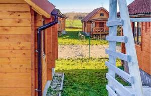 a wooden building with a ladder next to a yard at Gorgeous Home In Rybical With Kitchen in Ryn +3 photos